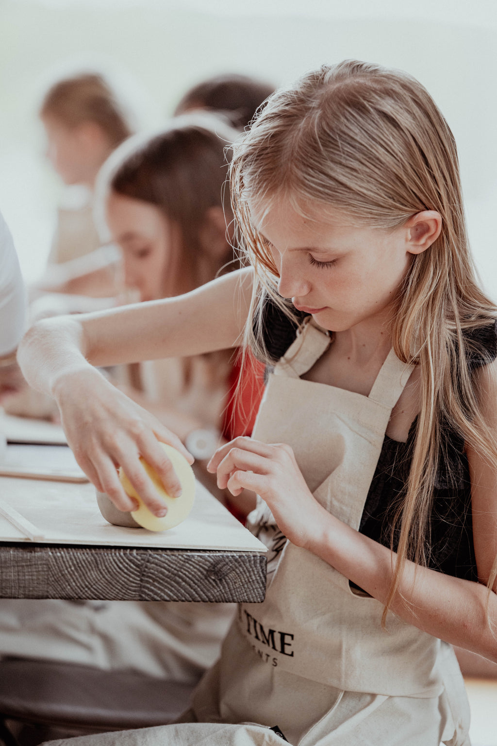 Kind töpfert konzentriert eine Tonschale im Töpferkurs für Kinder bei Happy Time Pottery in Potsdam.