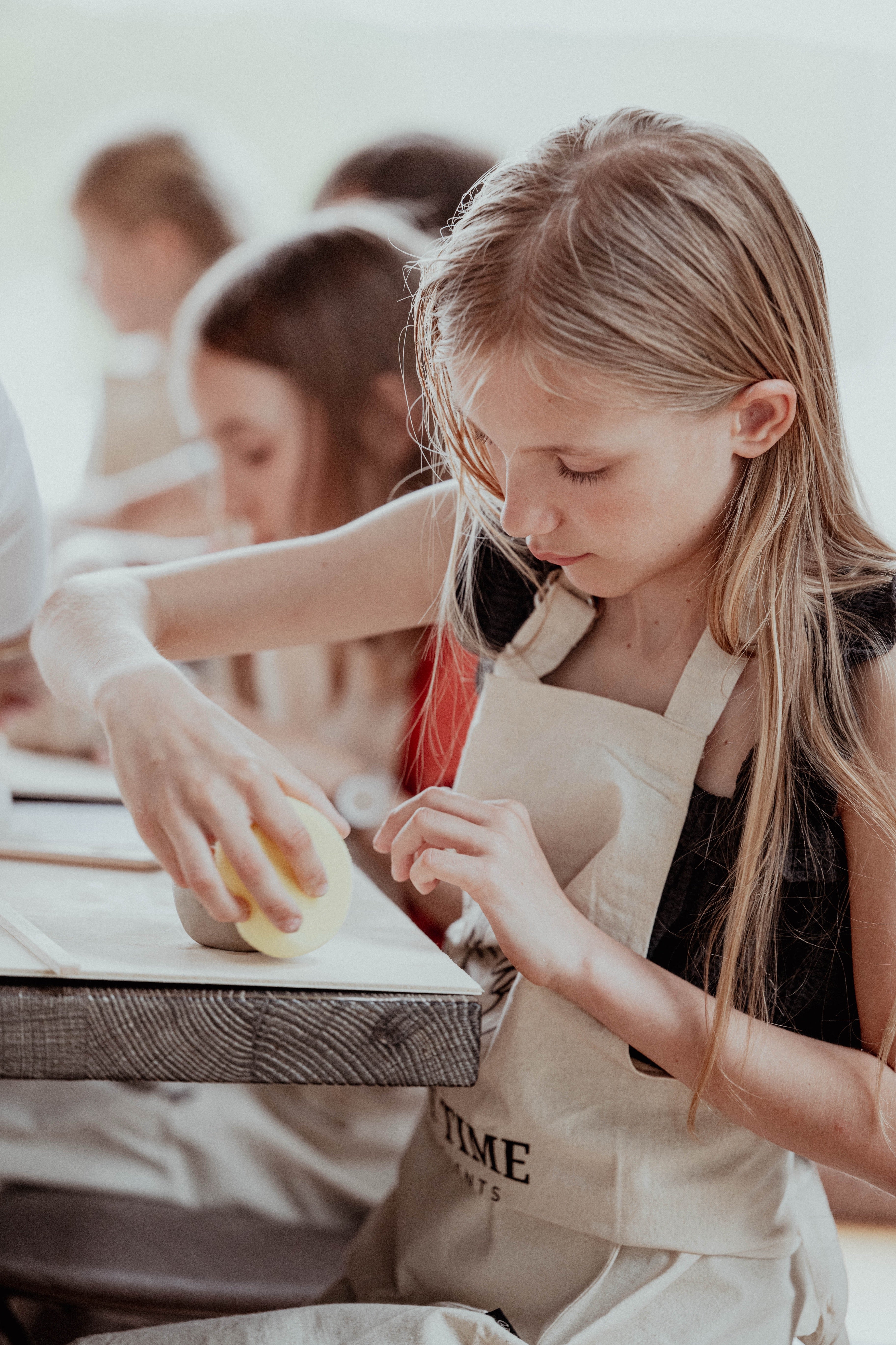 Kind töpfert konzentriert eine Tonschale im Töpferkurs für Kinder bei Happy Time Pottery in Potsdam.