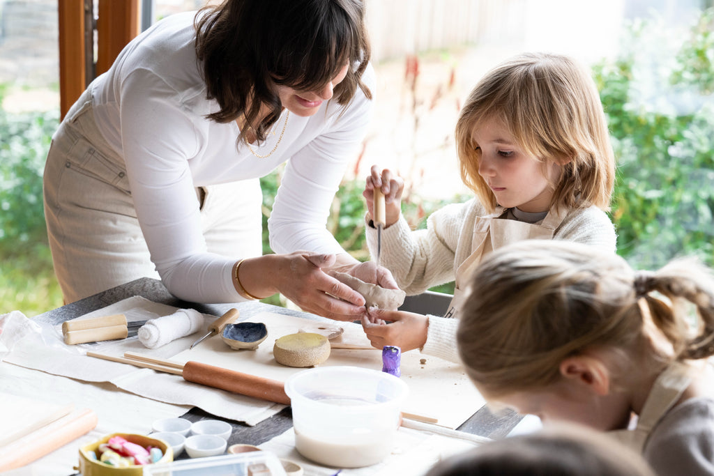 Kind lernt spielerisch unter Anleitung zu töpfern bei Happy Time Pottery Kindertöpfern in Potsdam