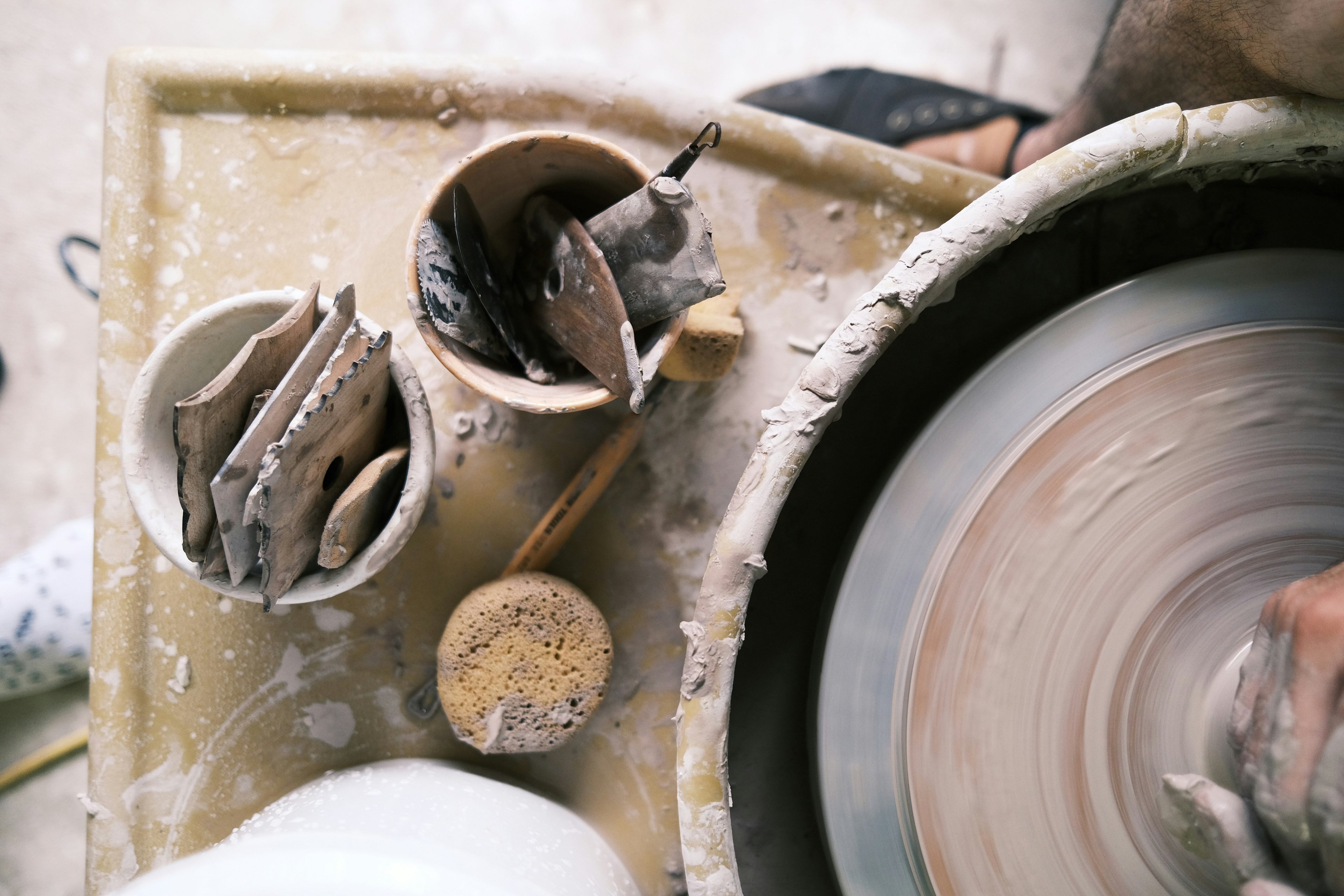 Teilnehmer lernt das Drehen an der Töpferscheibe im Kurs bei Happy Time Pottery in Potsdam.