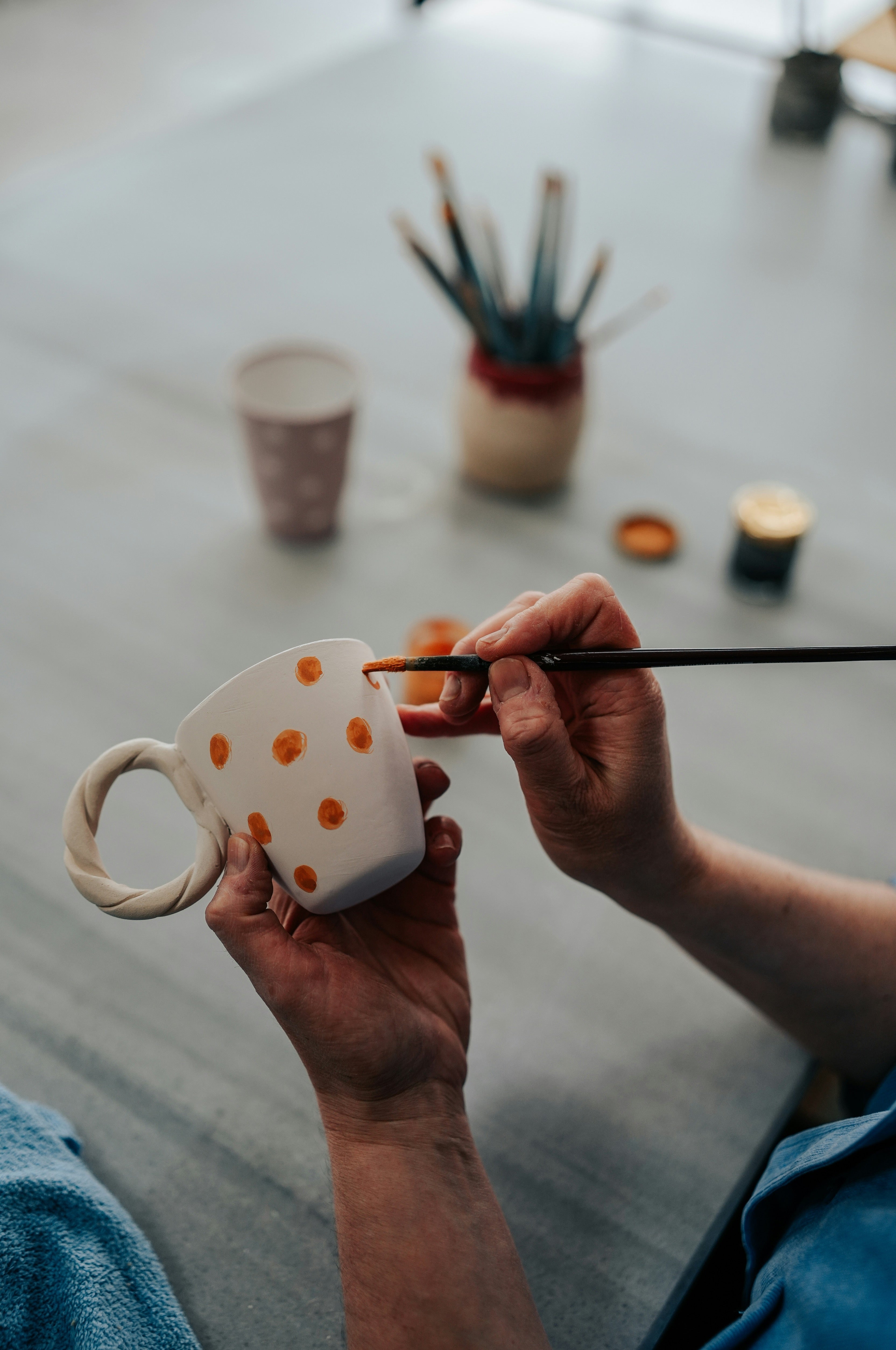 Teilnehmer verziert eine selbstgemachte Tasse im Glasur-Workshop in einem Potsdamer Töpferstudio